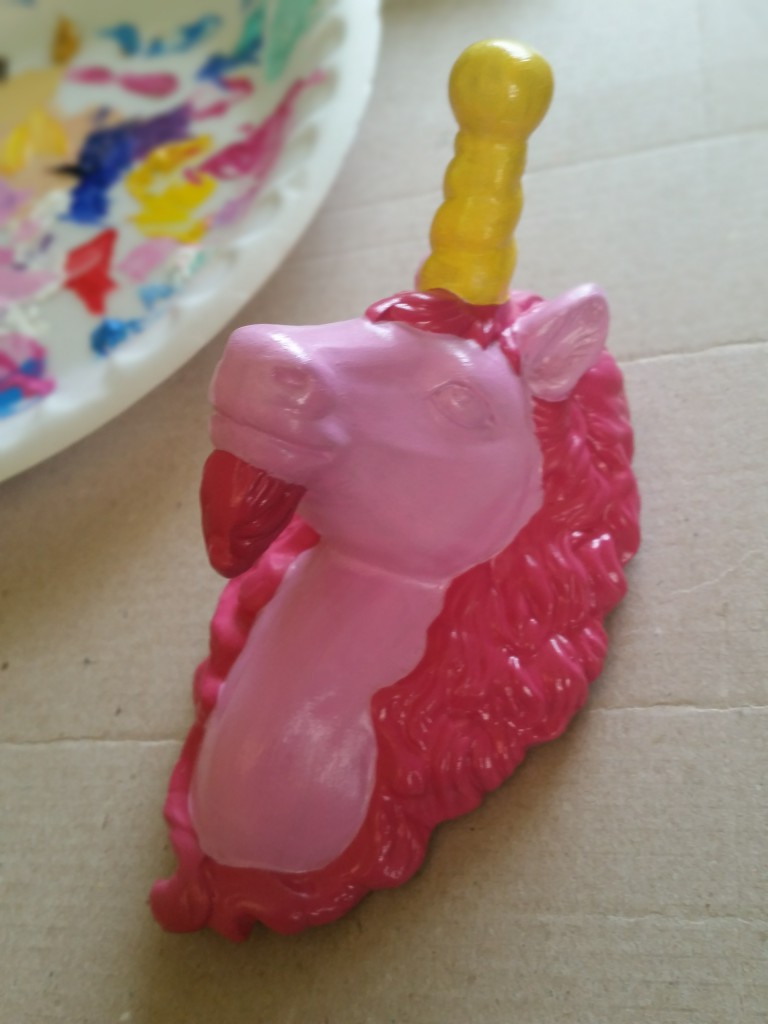a glossy painted unicorn head, two shades of pink